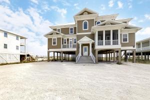 a large house sitting on top of a beach at Windswept by Meyer Vacation Rentals in Gulf Shores