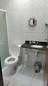 a bathroom with a toilet and a sink at Maravilhosa casa na praia do Francês in Praia do Frances +14 photos