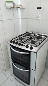 a stove top oven in a white kitchen at Maravilhosa casa na praia do Francês in Praia do Frances