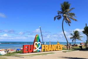 a sign on a beach with a palm tree at Maravilhosa casa na praia do Francês in Praia do Frances