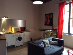 a living room with a couch and a microwave at Appartement Roquette Serenity in Arles