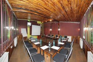 a conference room with tables and chairs and a whiteboard at Villa Select in Predeal