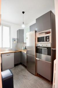 a kitchen with a stainless steel refrigerator and appliances at Charming T2 on the outskirts of Paris in Saint-Ouen
