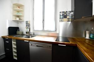 a kitchen with a sink and a wooden counter top at Charming T2 on the outskirts of Paris in Saint-Ouen