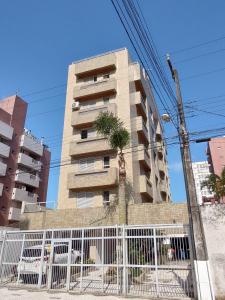 a tall building with a palm tree in front of it at Apartamento em Caioba com wi-fi in Matinhos