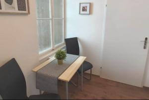 - une table à manger avec deux chaises et une plante en pot dans l'établissement Cozy new apartment near Hannovermarkt, à Vienne