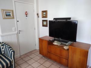 a living room with a flat screen tv on a dresser at Apartamento em Caioba com wi-fi in Matinhos