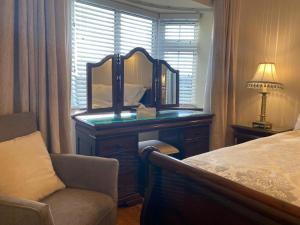 a bedroom with a dresser with a mirror and a chair at Woodhaven Manor h91rc9d in Galway