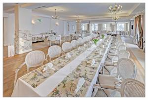 uma mesa longa com mesas brancas e cadeiras num quarto em Miód Lawenda em Biardy