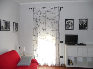 a living room with a red couch and a window at Il Mirto in Bari Sardo