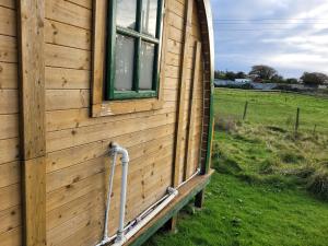 a building with a window on the side of it at St Austell Glamping Pod with Spa Pool and Pets Ok in Lanivet +7 photos