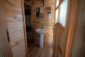 uma casa de banho com um lavatório branco num quarto de madeira em Alpstar Camping & Restaurant em Geyikbayırı