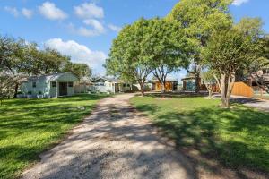 a dirt road in a yard with trees and houses at Guadalupe Bluff Farmhouse in Kerrville