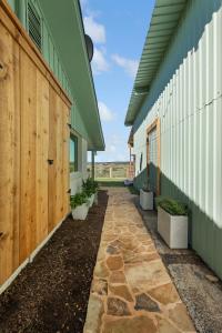 a walkway between two buildings with plants at Guadalupe Bluff Farmhouse in Kerrville