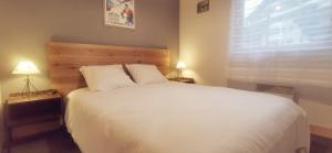 a bedroom with a large white bed and a window at Appartement 2 pièces au pied des télécabines in Saint-Gervais-les-Bains