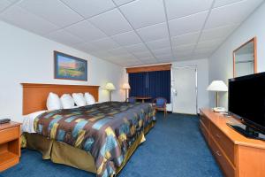 a hotel room with a bed and a flat screen tv at Corn Palace Inn in Mitchell