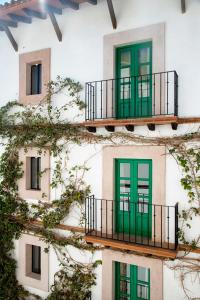 um edifício com portas verdes e uma varanda em William Hotel Boutique De Diseño em Taxco de Alarcón