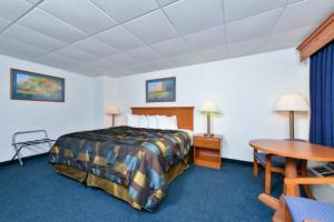 ein Hotelzimmer mit einem Bett und einem Tisch in der Unterkunft Corn Palace Inn in Mitchell