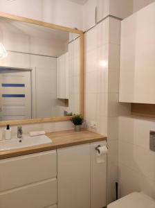 biała łazienka z umywalką i toaletą w obiekcie Lovely Apartment vis-a-vis Medicover and Paley Institute w Warszawie