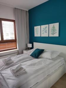 sypialnia z białym łóżkiem i niebieską ścianą w obiekcie Lovely Apartment vis-a-vis Medicover and Paley Institute w Warszawie