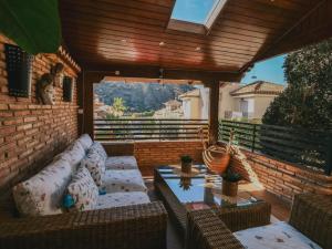 eine Terrasse mit Sofas und einem Tisch an einer Backsteinwand in der Unterkunft Apartamentos Turísticos Tronca Luxury in Granada