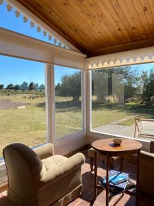 un porche cubierto con 2 ventanas y una mesa en La Elvira Natural Lodge en Punta Delgada