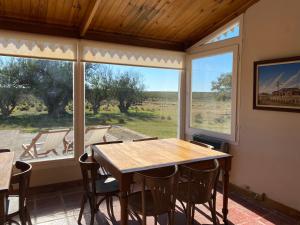 a dining room with a table and a large window at La Elvira Natural Lodge in Punta Delgada