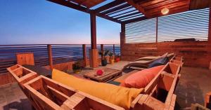 een balkon met een bank en uitzicht op de oceaan bij Little Paradise House in Agadir