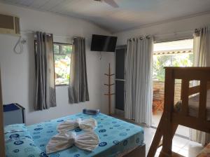 a bedroom with a bed with bows on it at Suítes Carla e Carol in Praia de Araçatiba