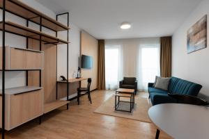 un soggiorno con divano blu e tavolo di Hotel Tulip Residences Warsaw Targowa a Varsavia