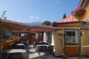restauracja ze stołami i parasolami na patio w obiekcie Edelsteinhotel Guniwirt w mieście Krakaudorf