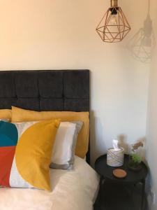 a bed with a black headboard and a side table at The TollHouse in Stirling