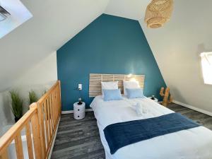 sypialnia z dużym łóżkiem z niebieską ścianą w obiekcie Cosy Casa w mieście Abbeville