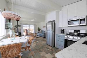 Una cocina con gabinetes blancos y una mesa con sillas. en Summer Delight, en Avila Beach