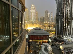 Ultimate Stay / 2 Beds / Opera and Fountain views في دبي: اطلالة على المدينة ليلا من مبنى