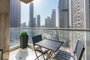 einen Balkon mit einem Tisch und Stühlen sowie Stadtblick in der Unterkunft Ultimate Stay / 2 Beds / Opera and Fountain views in Dubai