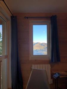 a room with a window with blue curtains and a bed at Appartement ski Station Val Louron - Au pied des pistes - 4 - 6 personnes in Génos