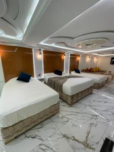 three beds in a room with marble floors at appart hotel puerto marino in Al Hoceïma