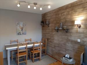 a dining room with a wooden wall at VALMEINIER - LE GRAND PANORAMA II - Piscine intérieure in Valmeinier