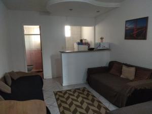 a living room with a couch and a kitchen at Apto flat Antônio in Campos dos Goytacazes +4 photos