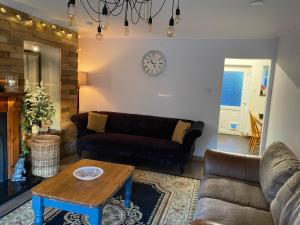 uma sala de estar com um sofá e uma mesa em Claire's Townhouse, Aberdeenshire, 3 bedrooms em Oldmeldrum