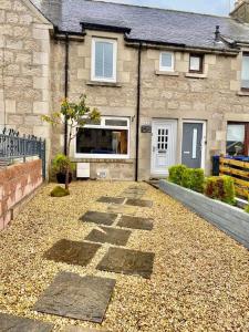 a house with a gravel driveway in front of it at Claire's Townhouse, Aberdeenshire, 3 bedrooms in Oldmeldrum