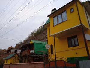 una casa amarilla en la cima de una colina en Садиба Каньйон, en Kamianets-Podilskyi