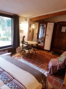 uma sala de estar com uma mesa e uma mesa em Petit Gîte avec SPA en Ariege Montagnes des Pyrénées em Péreille