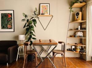 a table and chairs in a living room with a plant at Nyúlászó Vendégház Stúdiólakás in Mád