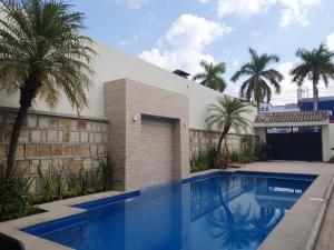 una piscina frente a una casa con palmeras en Casa AMMAH, en Ciudad Valles