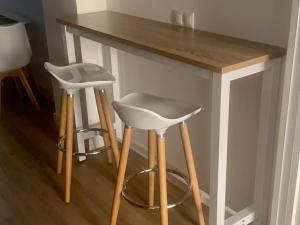a table with two stools and a counter top at Puerta de Caceres Apartamento 3 in Cáceres