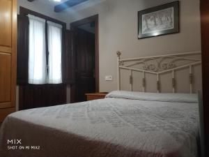 um quarto com uma cama e uma janela em El Cantón em Cangas de Onís