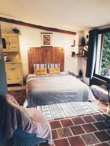a bedroom with a bed and a brick floor at Petit Gîte avec SPA en Ariege Montagnes des Pyrénées in Péreille