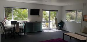 a living room with a table and a tv at Affordable, Spacious, Bright, Warm, Unit in Central Whangarei in Whangarei